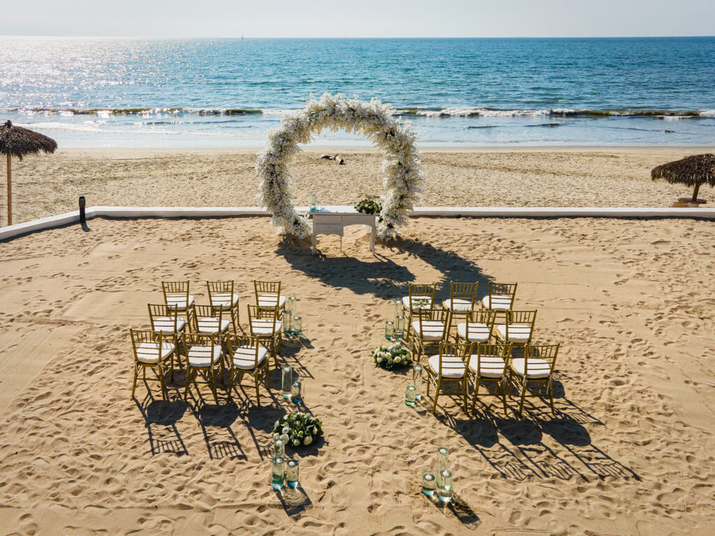 simple destination wedding on sand, ocean in background, white flowers 